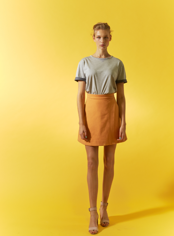 Girl in Funktion Schnitt t-shirt and orange skirt collaboration with SEAQUAL INITIATIVE